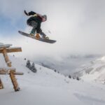 man-in-black-snowboard-met-binding-voert-een-sprong