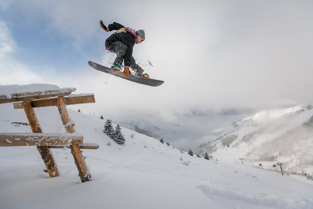 man-in-black-snowboard-met-binding-voert-een-sprong